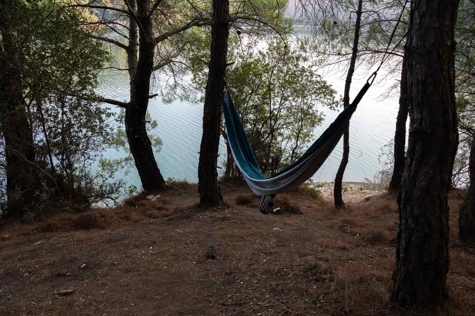Wide nylon camping hammock hung with a deep sag between two trees