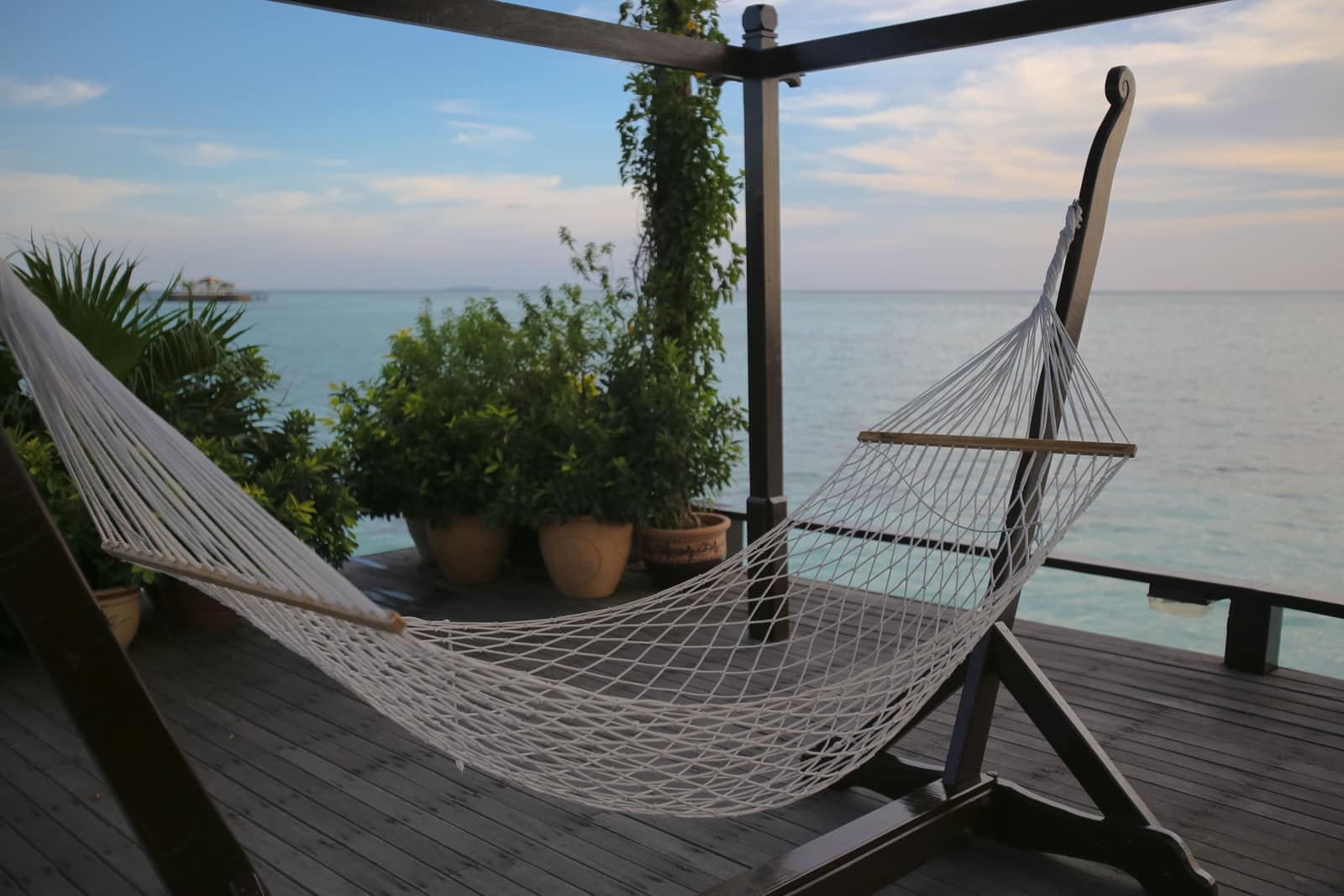 Spreader-bar hammock stretched open on a wooden deck