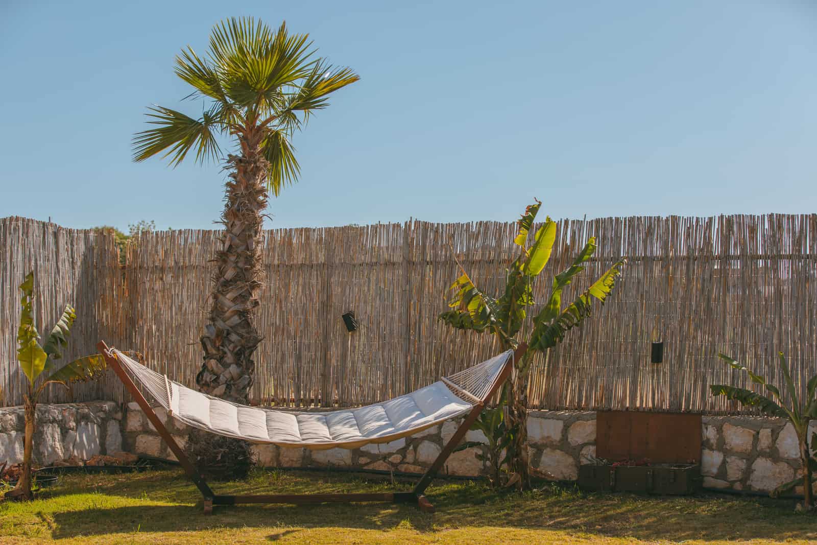 Wooden hammock stand beside a coated steel frame